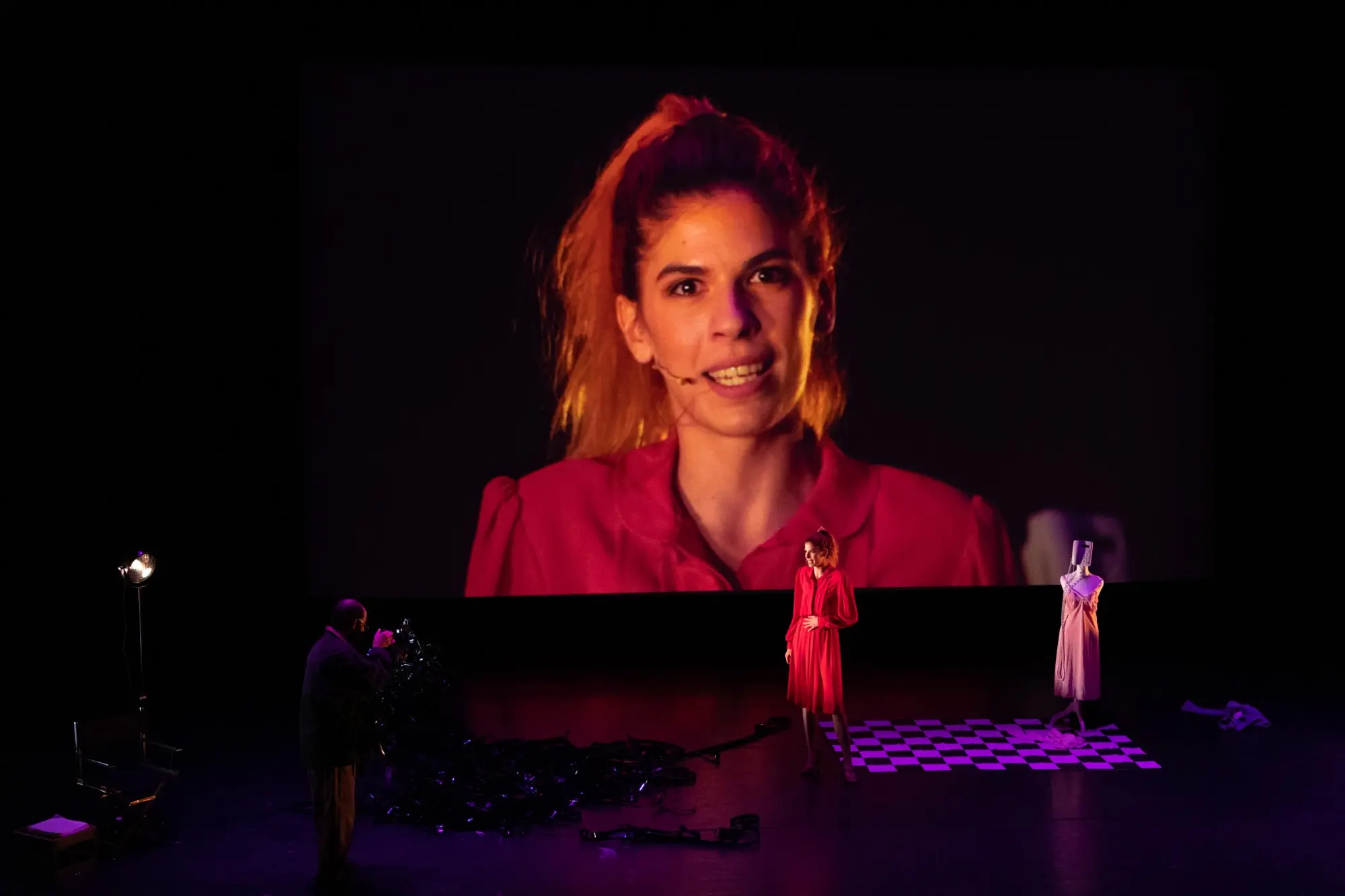 A woman appears in vivid pink projection