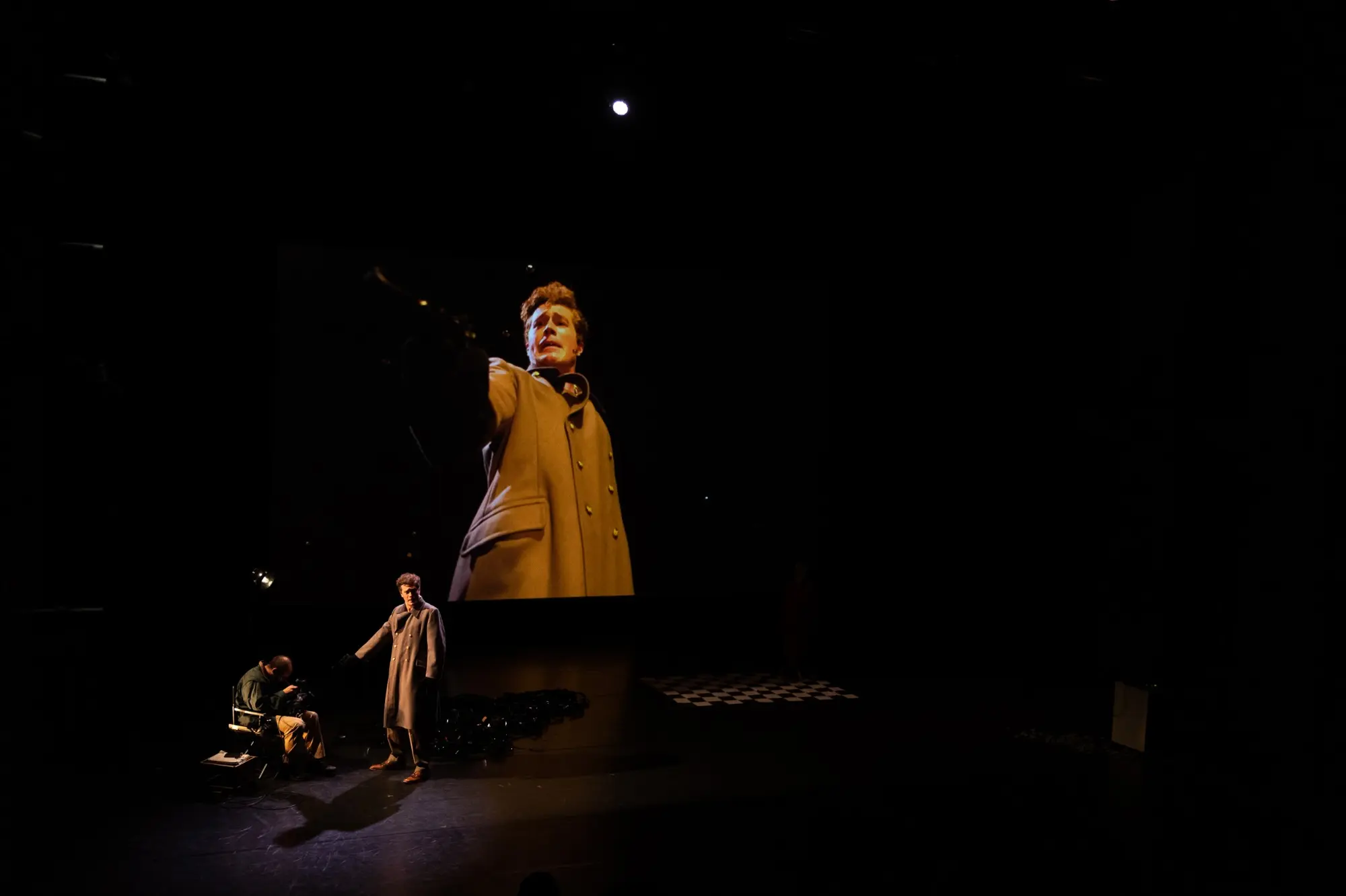 A performer stands in a field of darkness