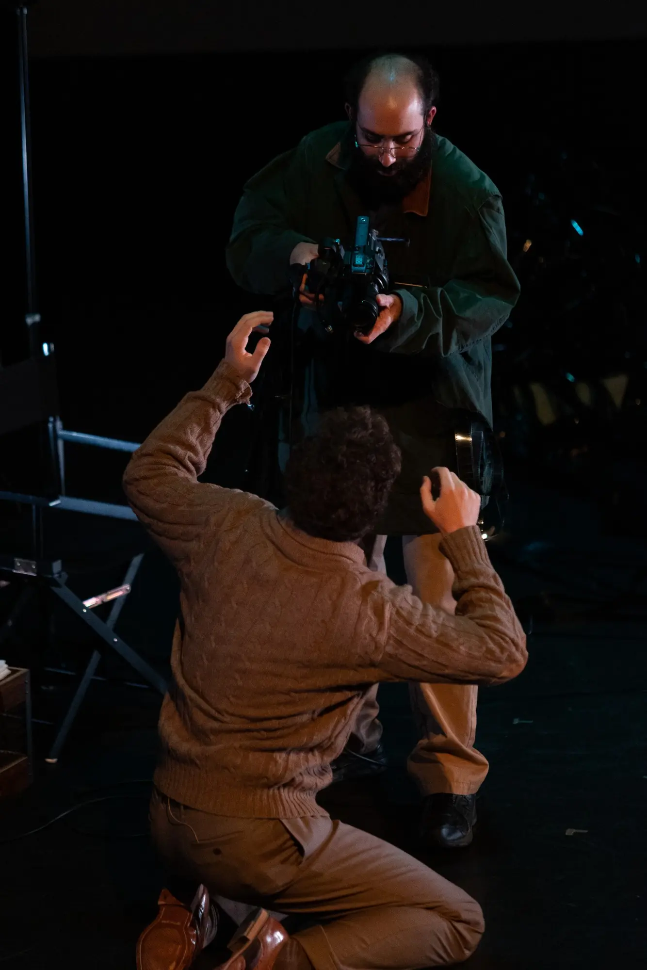 A camera operator films a seated performer