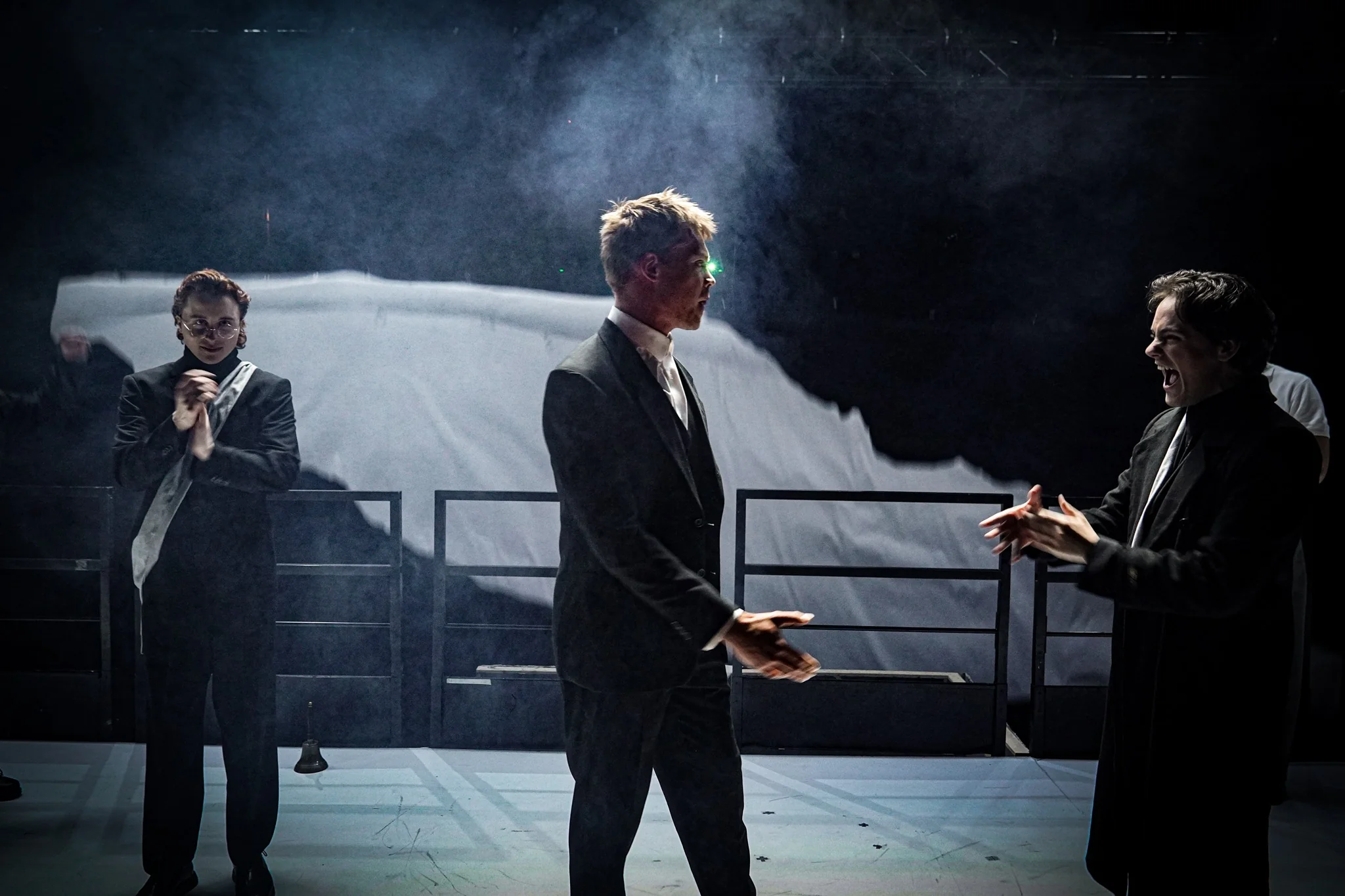 Three performers face each other on the quarry stage