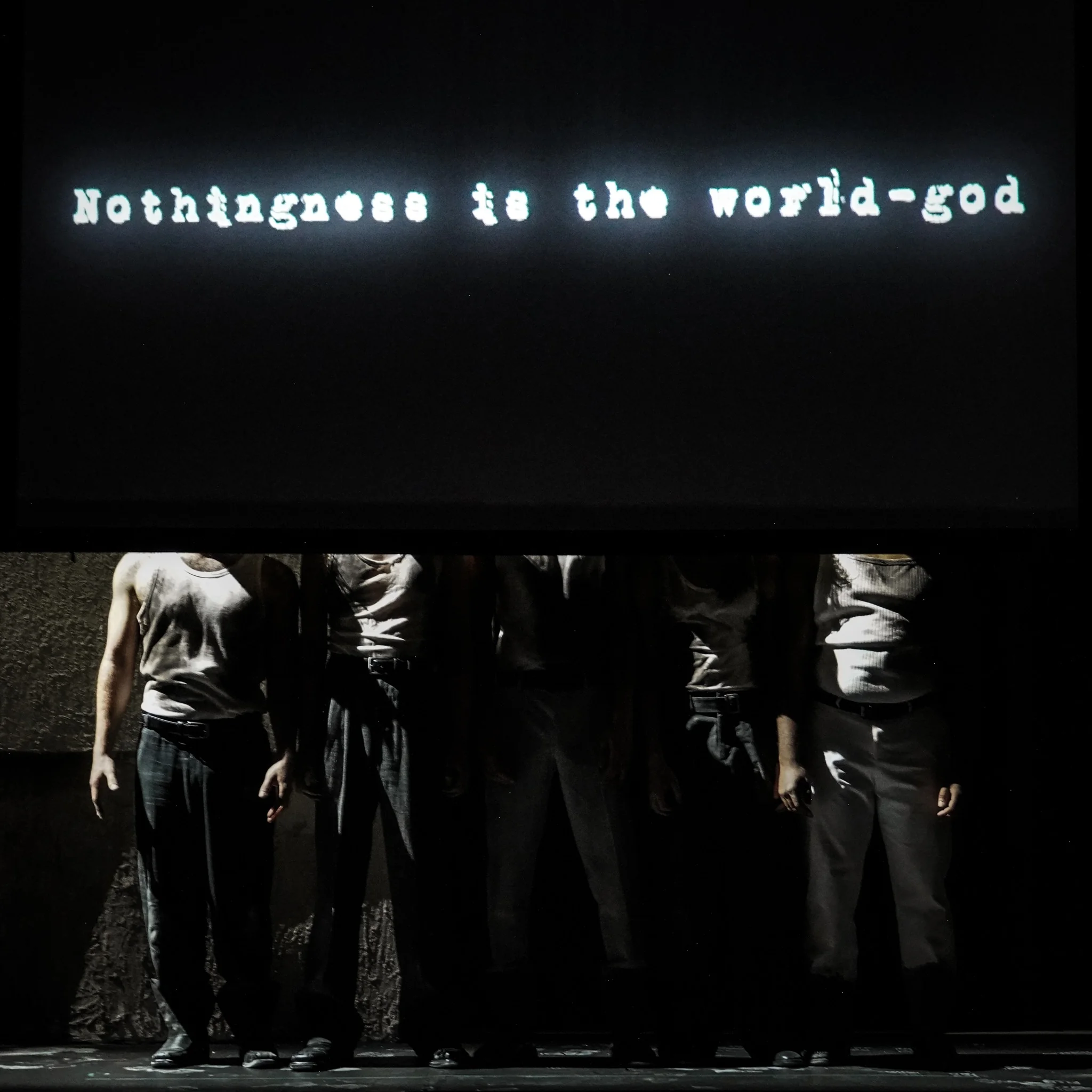 The company stands beneath a projection about nothingness