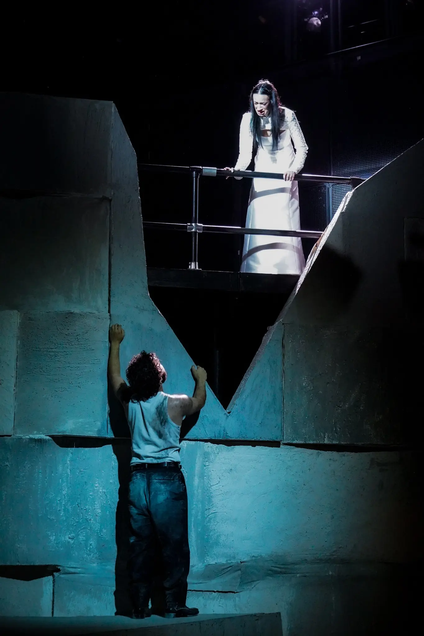 A performer isolated within the quarry-like stage