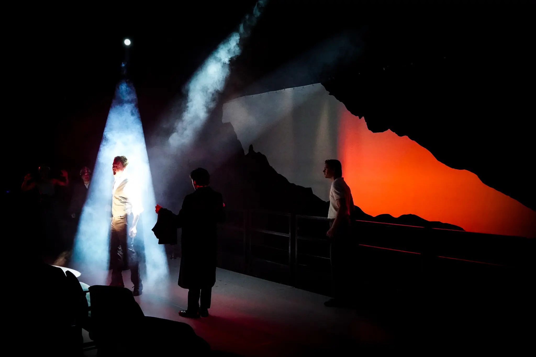 The ensemble fills the stage beneath monumental projections