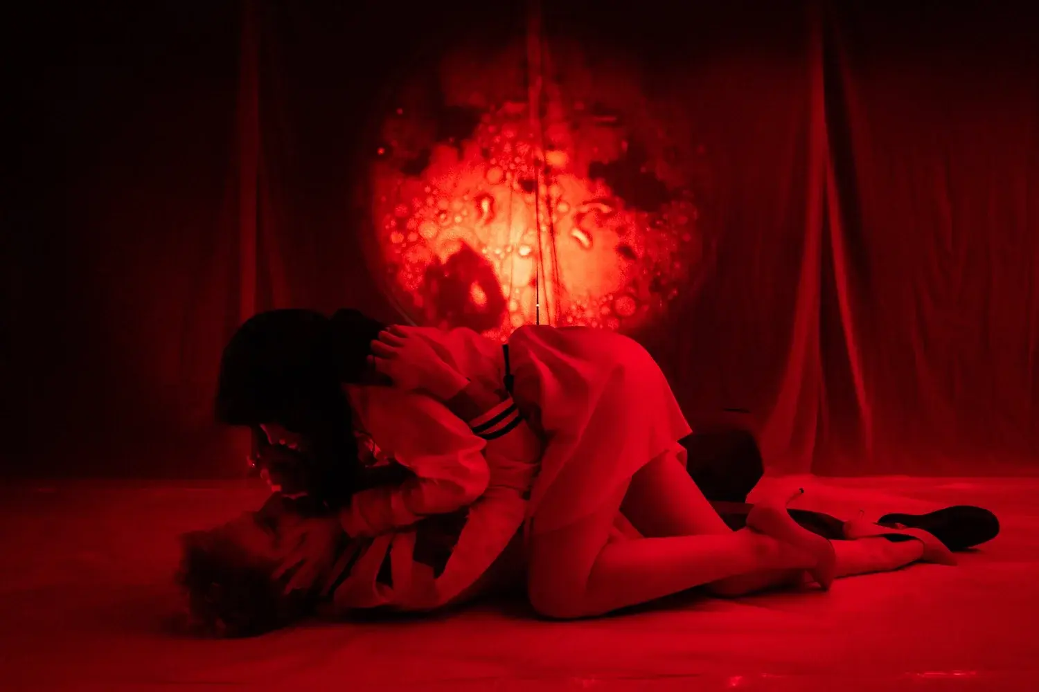 A performer is isolated beneath the laboratory lights